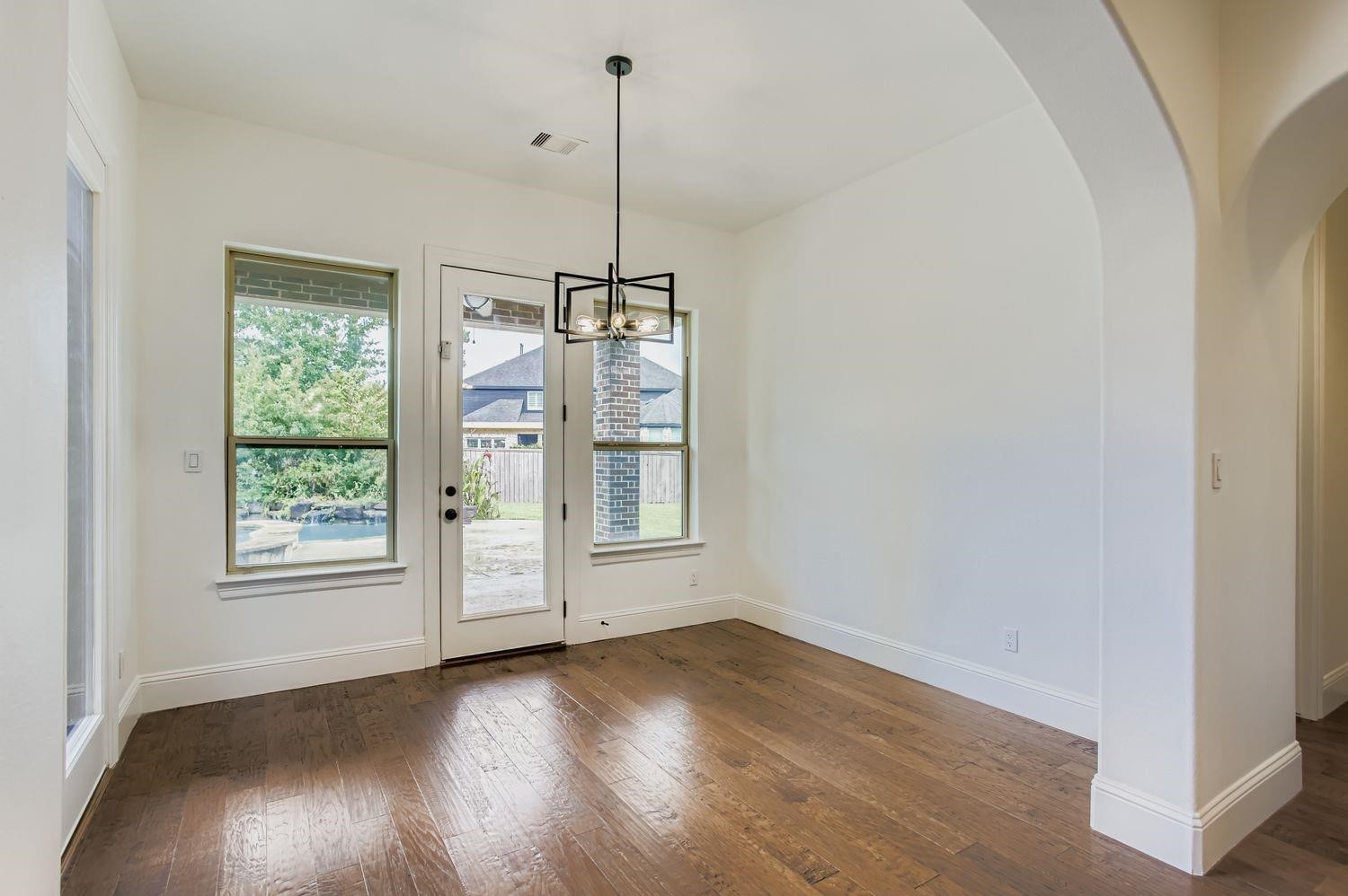 6 Freestone Stream Place The Woodlands, TX 77389 - Photo 22 of 50 a view of an empty room with wooden floor exposed radiator and a large window