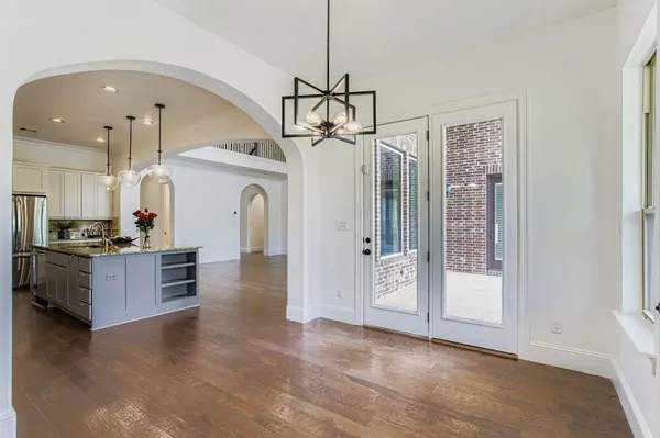 a view of a kitchen with a sink and dishwasher a refrigerator with wooden floor