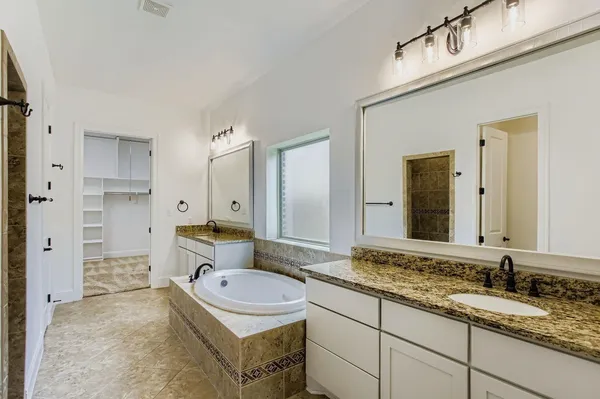 a bathroom with a granite countertop sink mirror and shower
