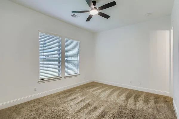 a view of a livingroom with a chandelier fan and wooden floor