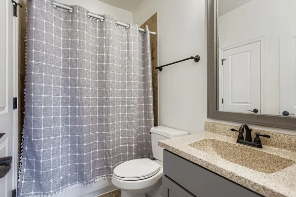 a bathroom with a granite countertop sink a mirror and a shower