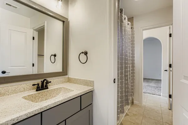 a bathroom with a granite countertop sink a toilet and a mirror