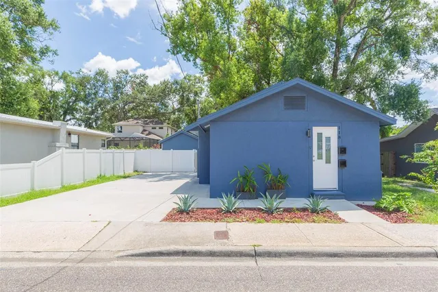 a front view of a house with a yard and potted plants