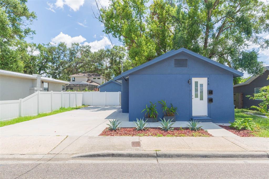 a front view of a house with a yard and potted plants