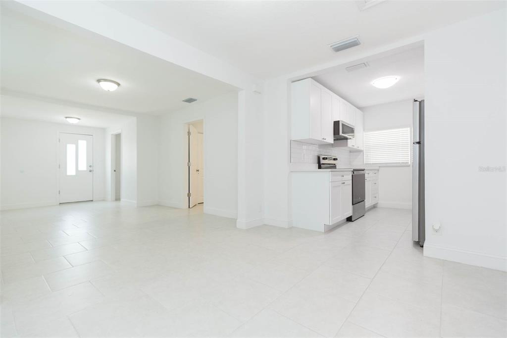 118 West Sligh Avenue Tampa, FL 33604 - Photo 11 of 20 a view of a kitchen with a sink and dishwasher a refrigerator with white cabinets