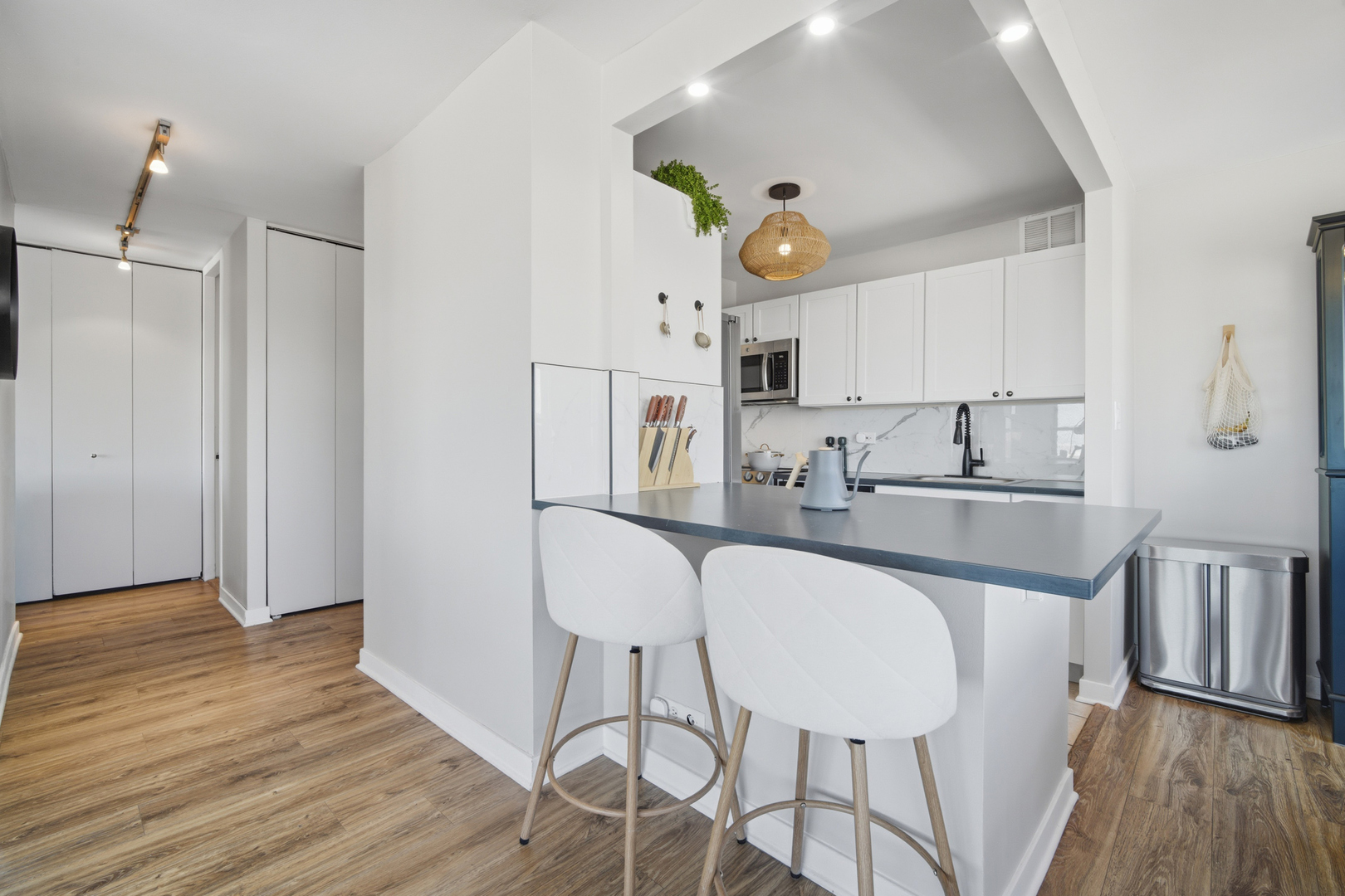 655 West Irving Park Road, Unit 2916 Chicago, IL 60613 - Photo 8 of 28 a kitchen with stainless steel appliances a dining table chairs and a refrigerator a sink with wooden floor