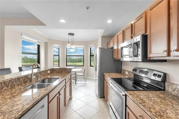 a kitchen that has a sink a stove and a table in it