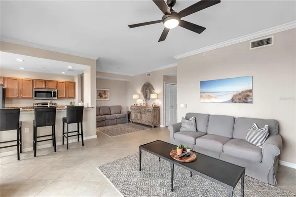 a living room with furniture kitchen view and a chandelier