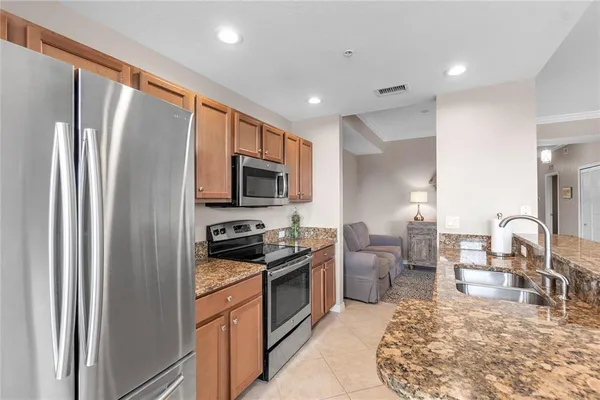 a kitchen with stainless steel appliances granite countertop a refrigerator stove and sink