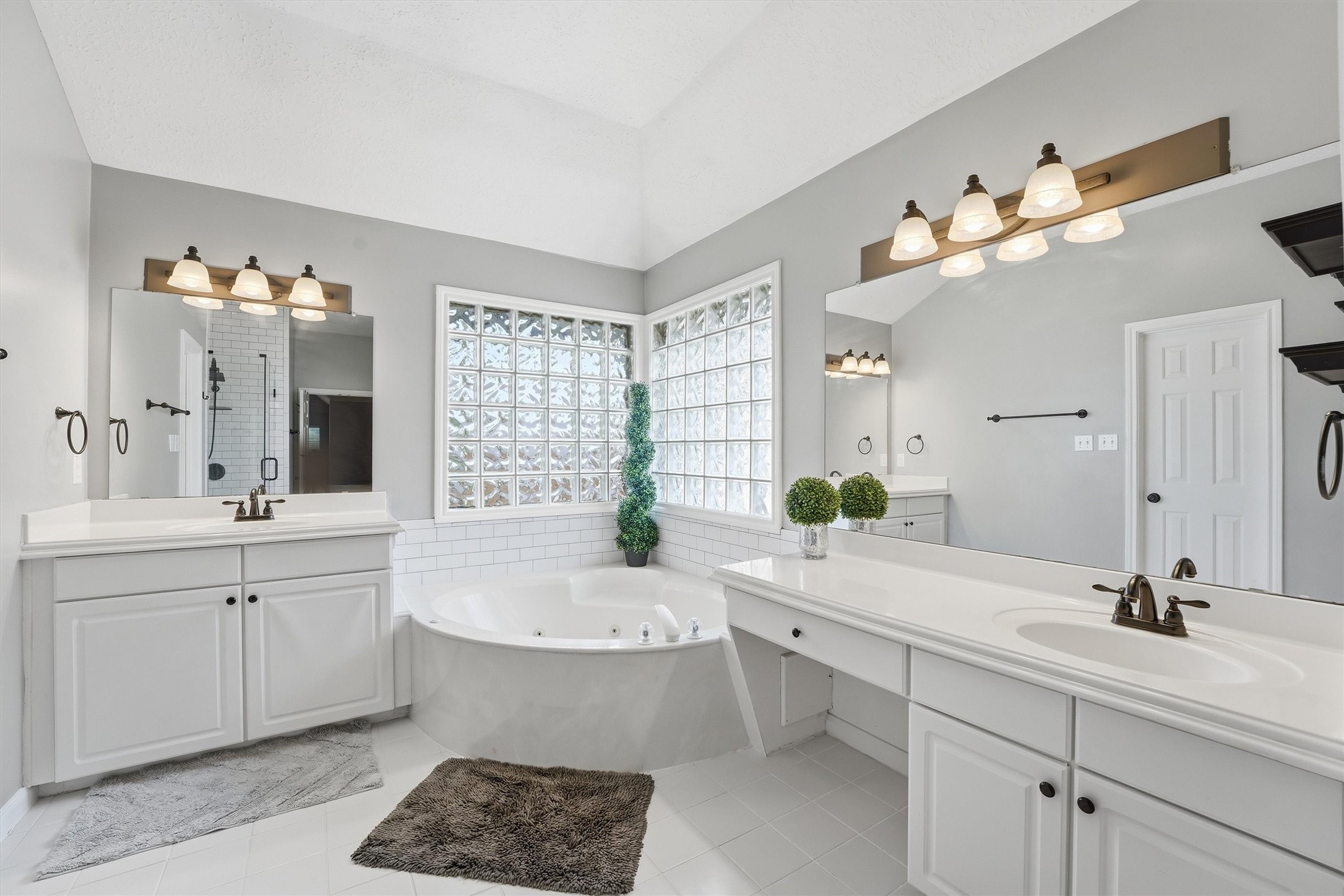 8827 Mile Run Road Humble, TX 77346 - Photo 21 of 37 a bathroom with a double vanity sink a bathtub and a window