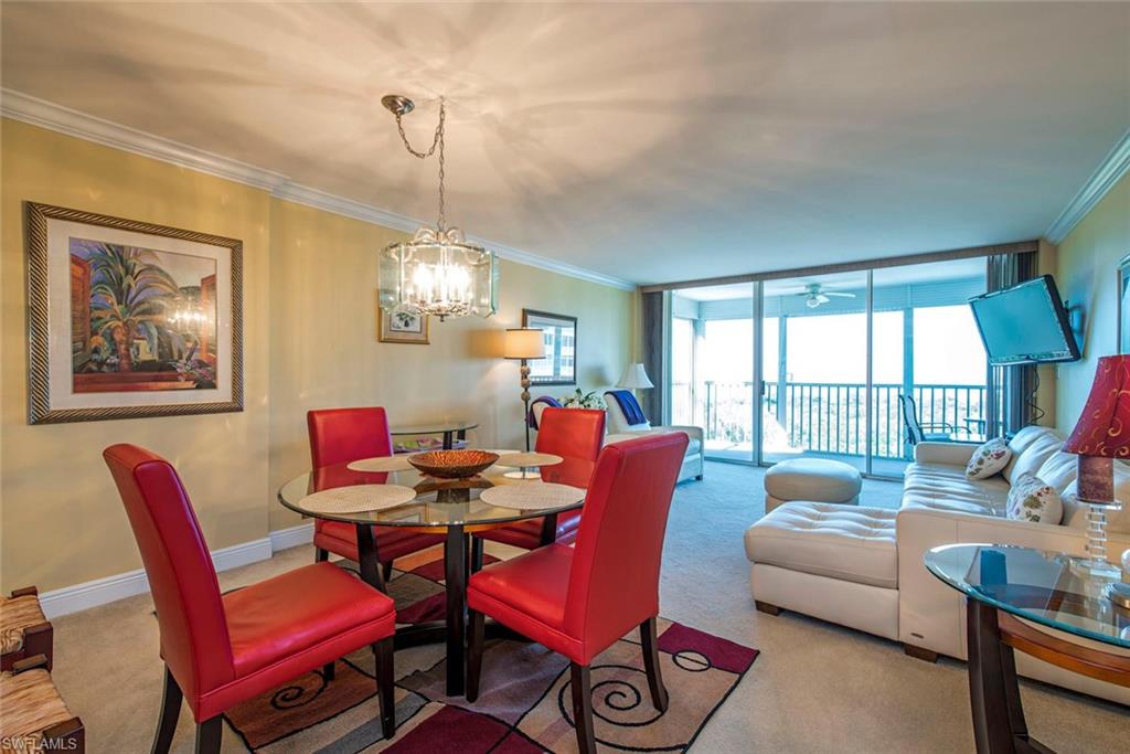3 Bluebill Avenue, Unit 704 Naples, FL 34108 - Photo 4 of 12 a dining room with furniture a chandelier and wooden floor