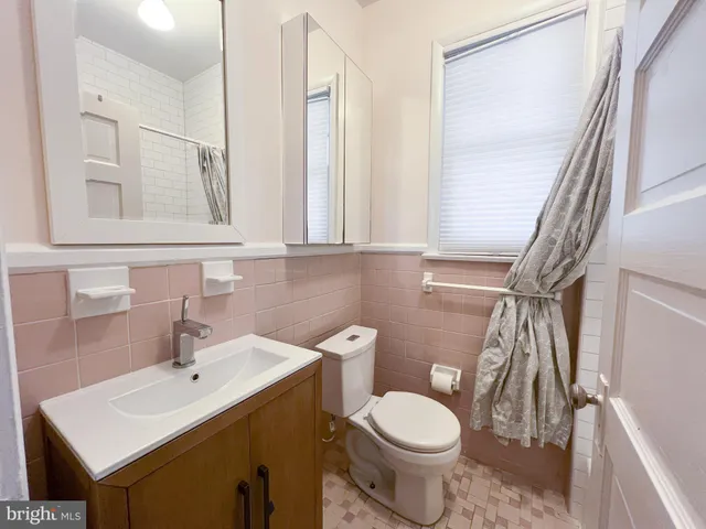 a bathroom with a toilet sink and mirror
