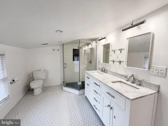 a spacious bathroom with a double vanity sink mirror and toilet