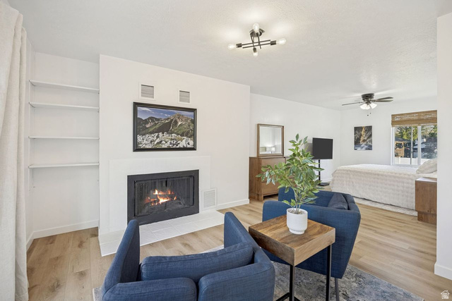 1723 Albury Road Sandy, UT 84092 - Photo 10 of 23 Primary bedroom sitting area, fireplace with a white surround and hearth, flanked by built-in shelving
