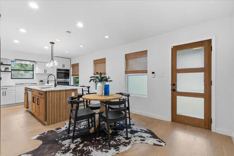 a kitchen with a table chairs refrigerator and cabinets