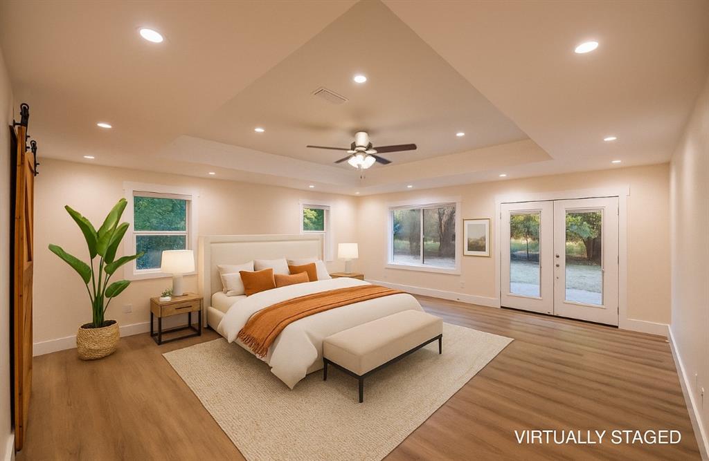 4505 Harrison Street Bellmead, TX 76705 - Photo 15 of 39 a spacious bedroom with a large bed and a wooden floor