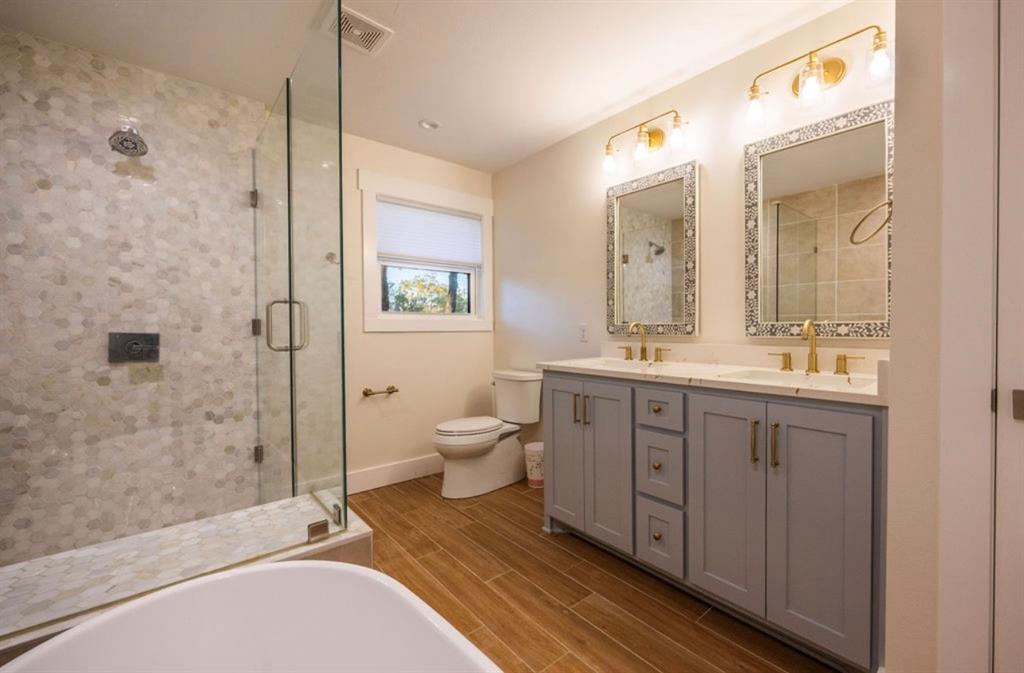 4505 Harrison Street Bellmead, TX 76705 - Photo 24 of 39 a spacious bathroom with a double vanity sink toilet mirror and shower