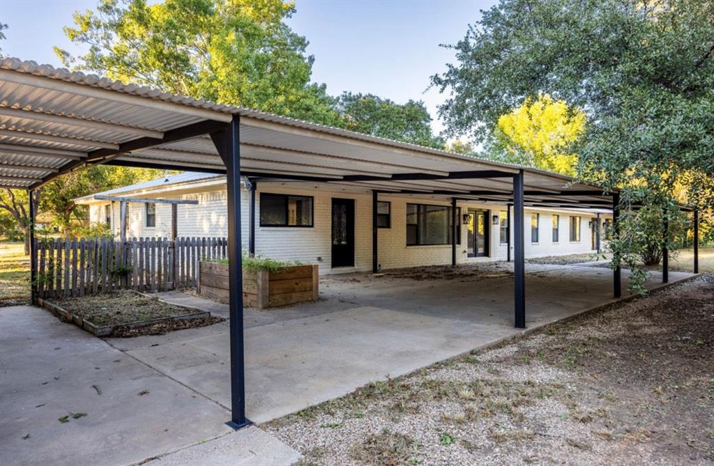 4505 Harrison Street Bellmead, TX 76705 - Photo 31 of 39 a view of a house with a large tree and wooden fence