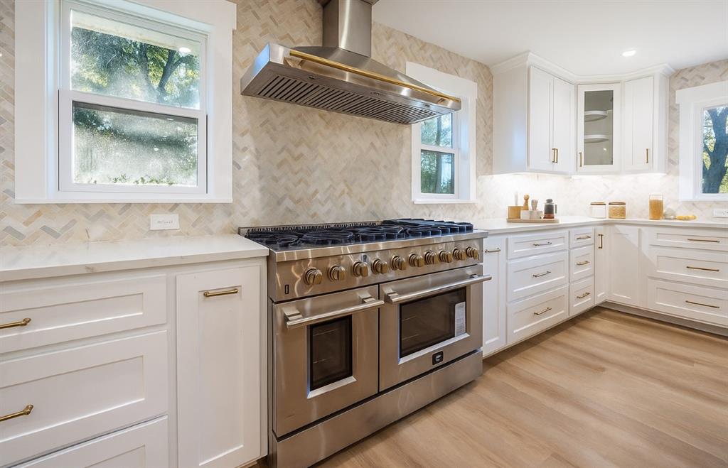 4505 Harrison Street Bellmead, TX 76705 - Photo 10 of 39 a kitchen with stainless steel appliances white cabinets and a wooden floor