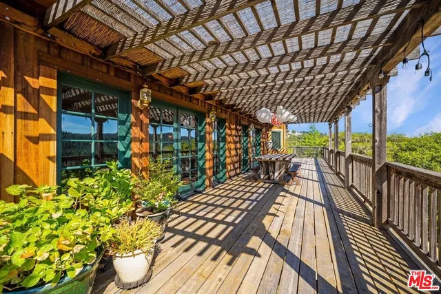 a view of a patio with table and chairs under an umbrella with wooden floor