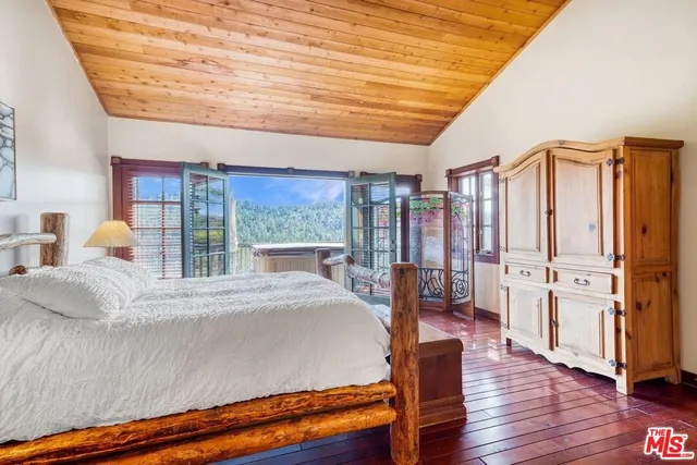 a kitchen with stainless steel appliances kitchen island granite countertop a table chairs in it and a wooden floor