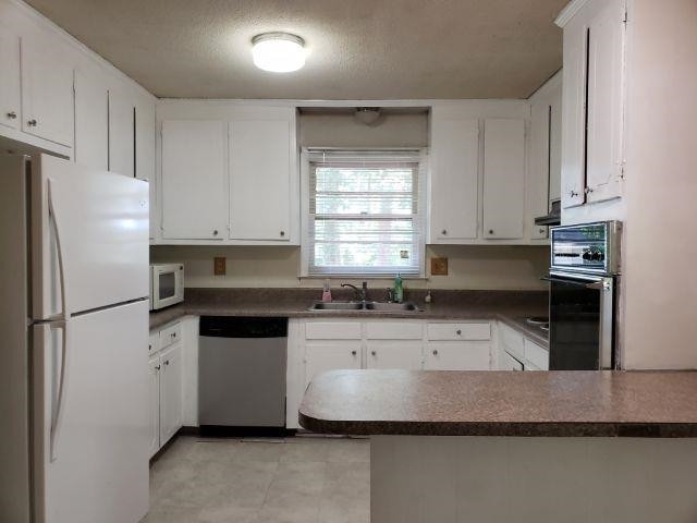 1133 Evans Road Cary, NC 27513 - Photo 5 of 9 a kitchen with granite countertop a refrigerator sink and white cabinets