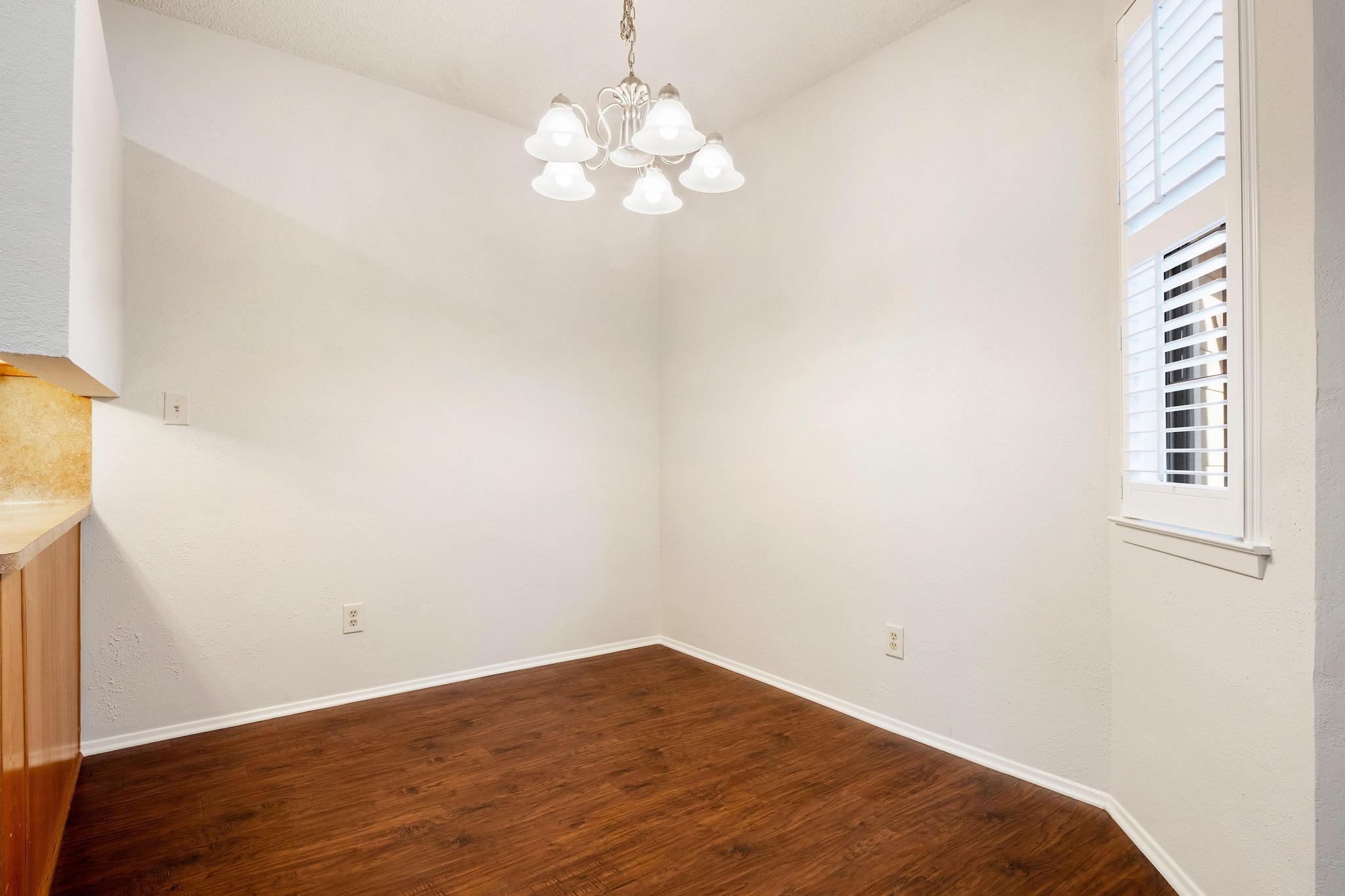 6501 Brush Country Road, Unit 109 Austin, TX 78749 - Photo 11 of 26 a view of a room with wooden floor and chandelier