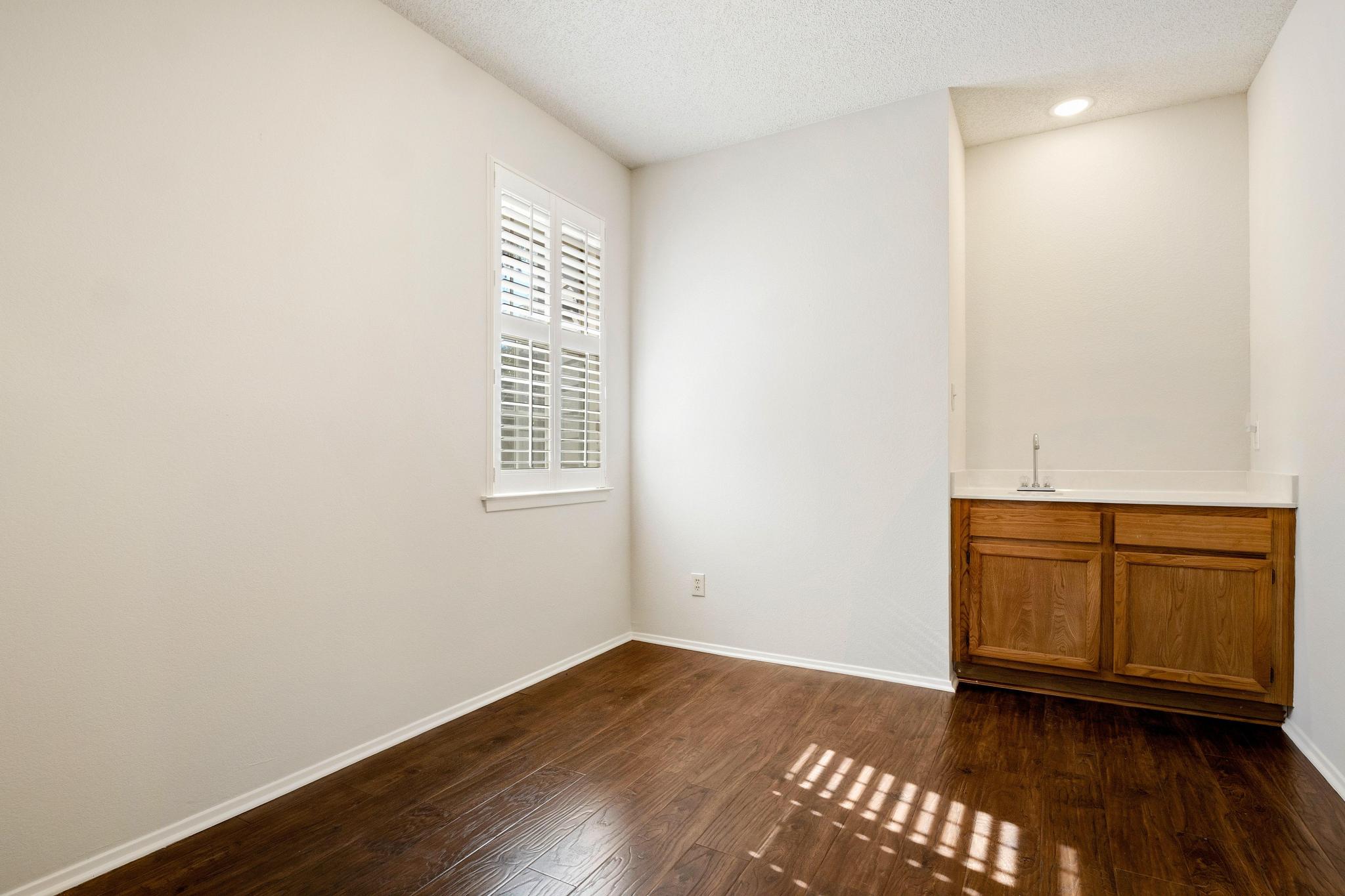 6501 Brush Country Road, Unit 109 Austin, TX 78749 - Photo 13 of 26 a view of an empty room with wooden floor and a window