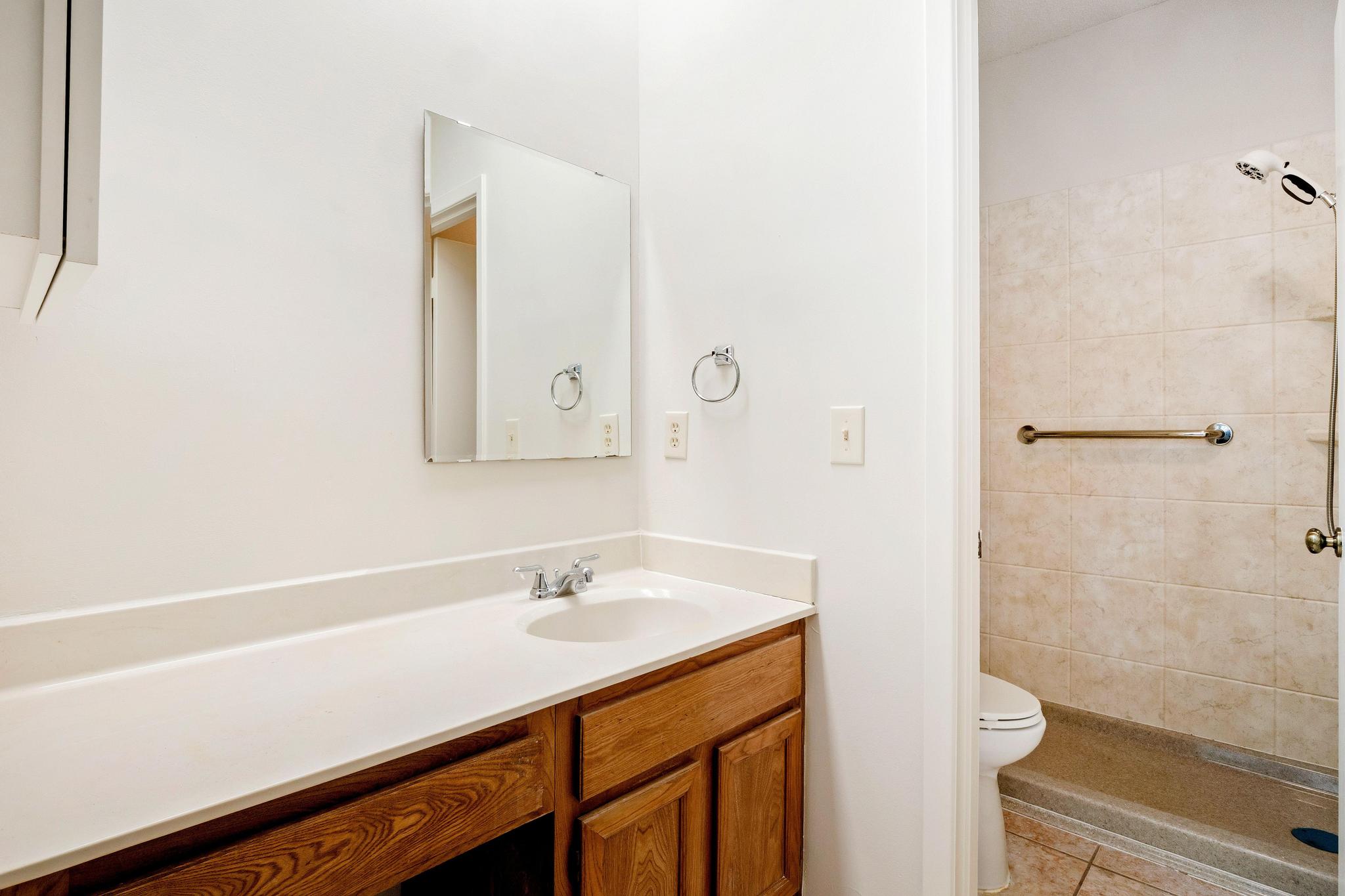 6501 Brush Country Road, Unit 109 Austin, TX 78749 - Photo 17 of 26 a bathroom with a sink a shower and a mirror