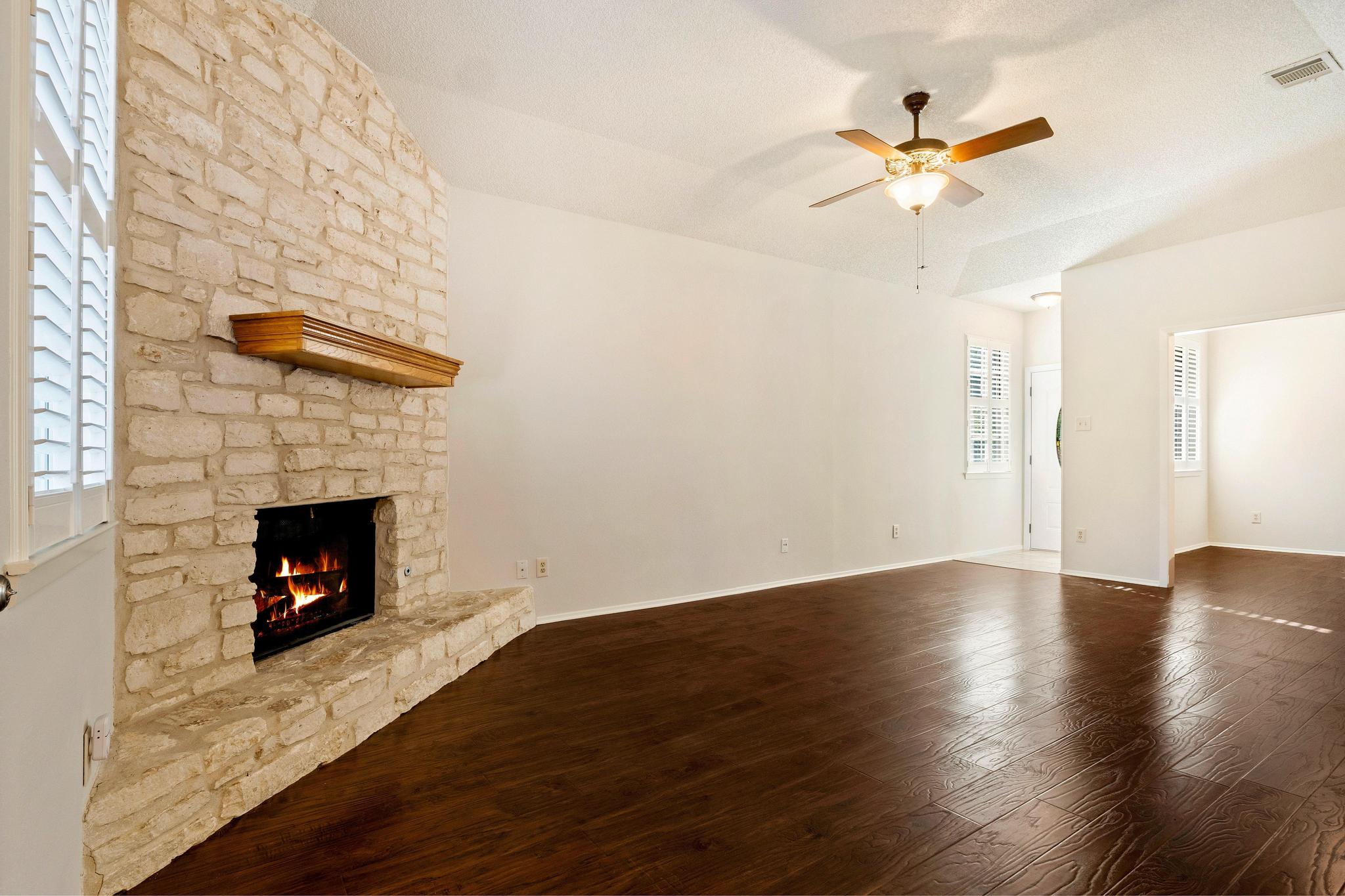6501 Brush Country Road, Unit 109 Austin, TX 78749 - Photo 5 of 26 a view of a livingroom with wooden floor and a fireplace