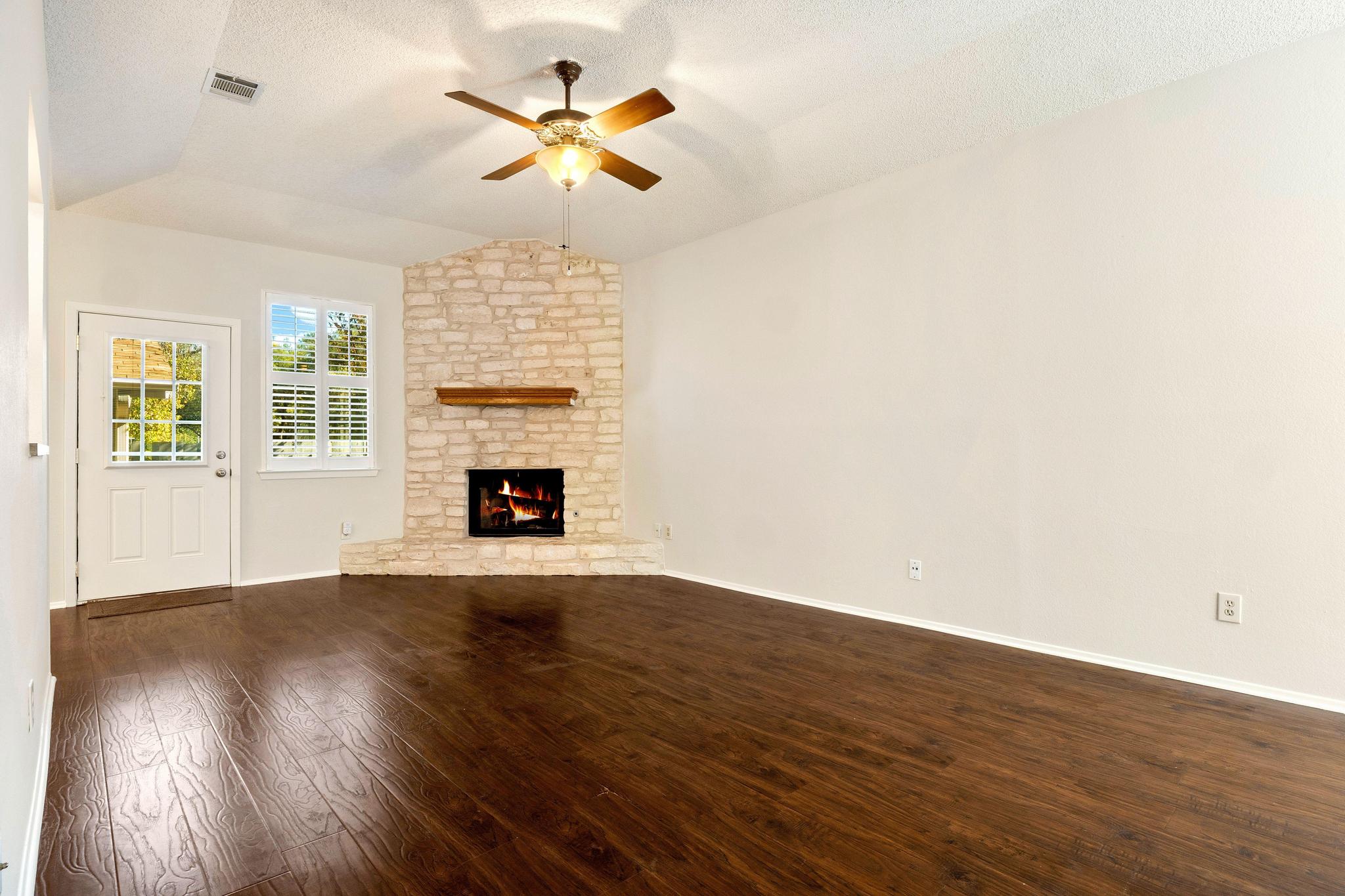 6501 Brush Country Road, Unit 109 Austin, TX 78749 - Photo 6 of 26 an empty room with wooden floor fireplace and window