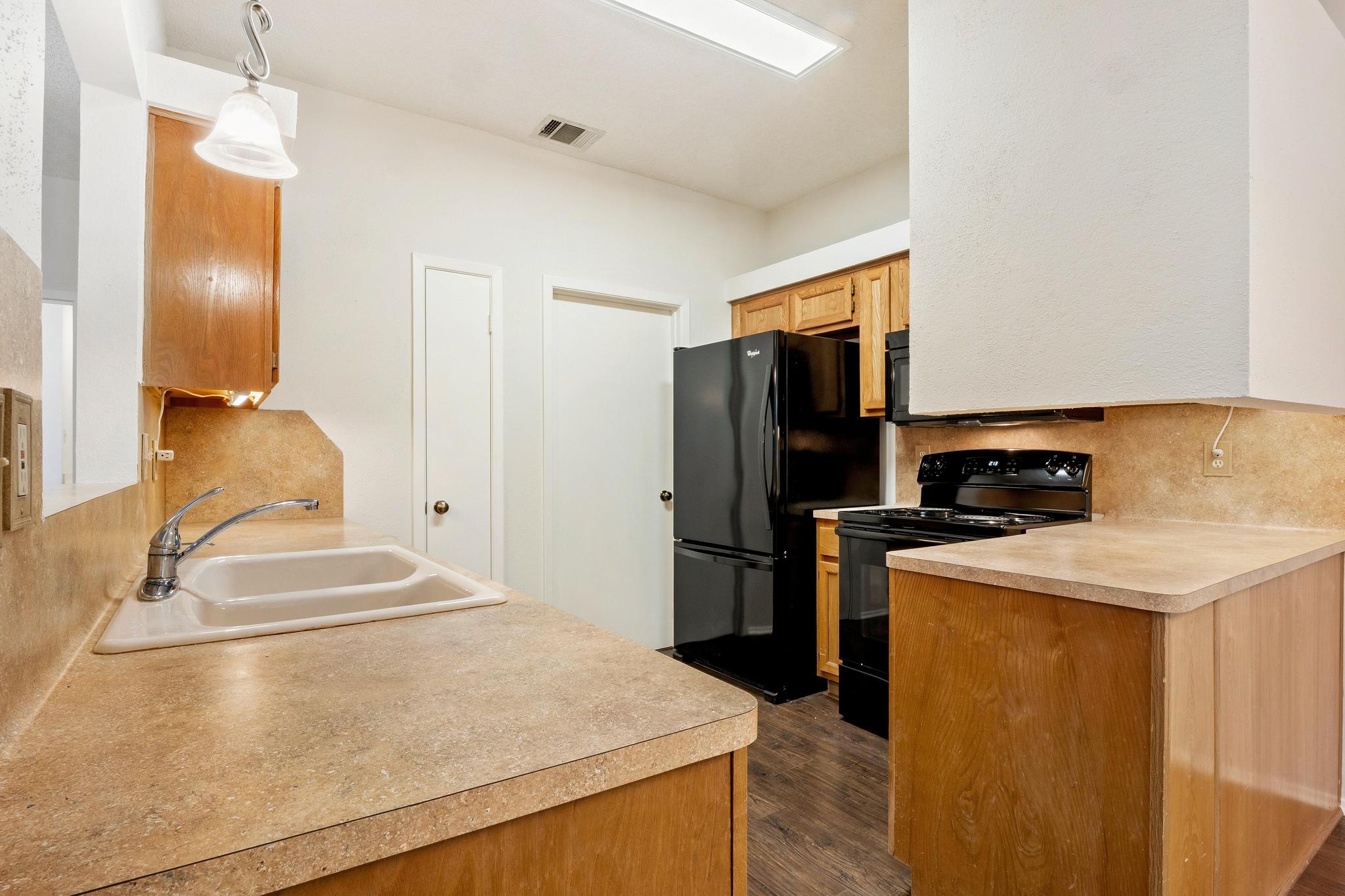 6501 Brush Country Road, Unit 109 Austin, TX 78749 - Photo 9 of 26 a kitchen with a sink a stove and refrigerator