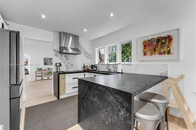 a kitchen with granite countertop white cabinets and white appliances