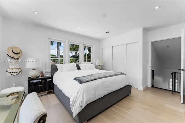 a bedroom with a large bed and windows