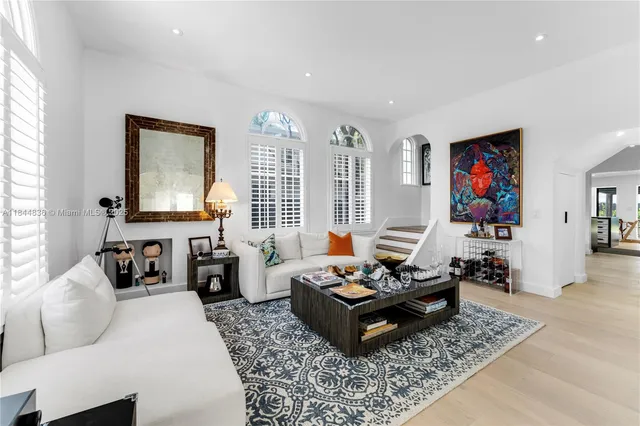 a living room with furniture and a dining table with wooden floor
