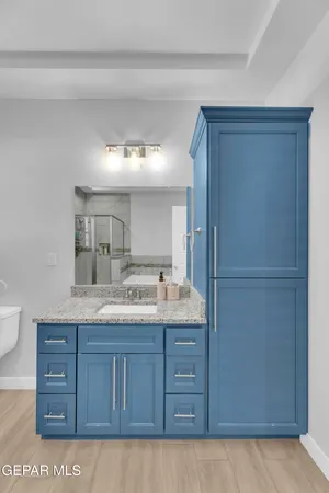 a bathroom with a granite countertop sink and a mirror