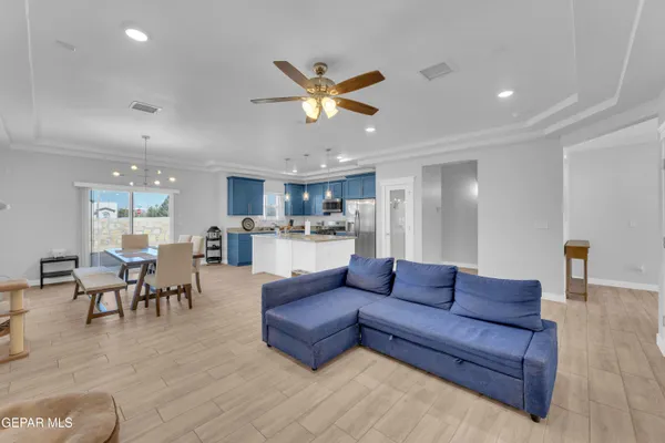 a living room with furniture kitchen view and a chandelier
