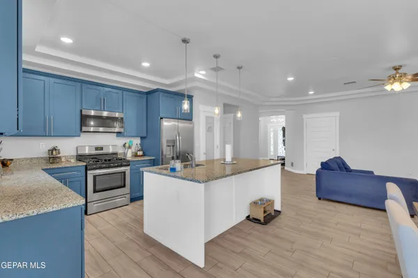 a large kitchen with stainless steel appliances granite countertop a stove and a refrigerator