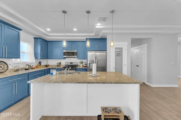 a kitchen with stainless steel appliances granite countertop a sink refrigerator and cabinets