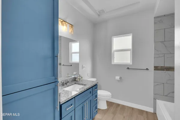 a bathroom with a granite countertop sink toilet and shower