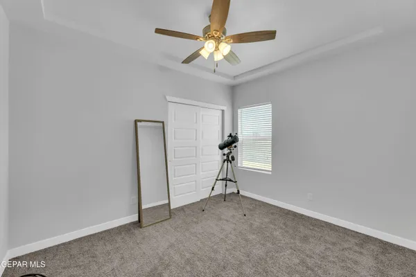 a view of an empty room with a ceiling fan