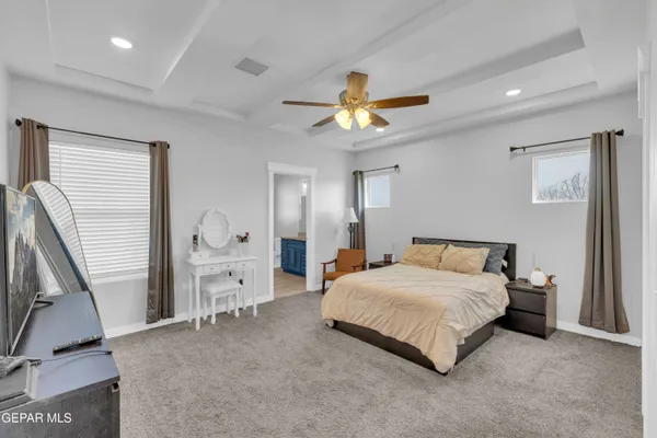 a bedroom with a bed a chandelier and dresser