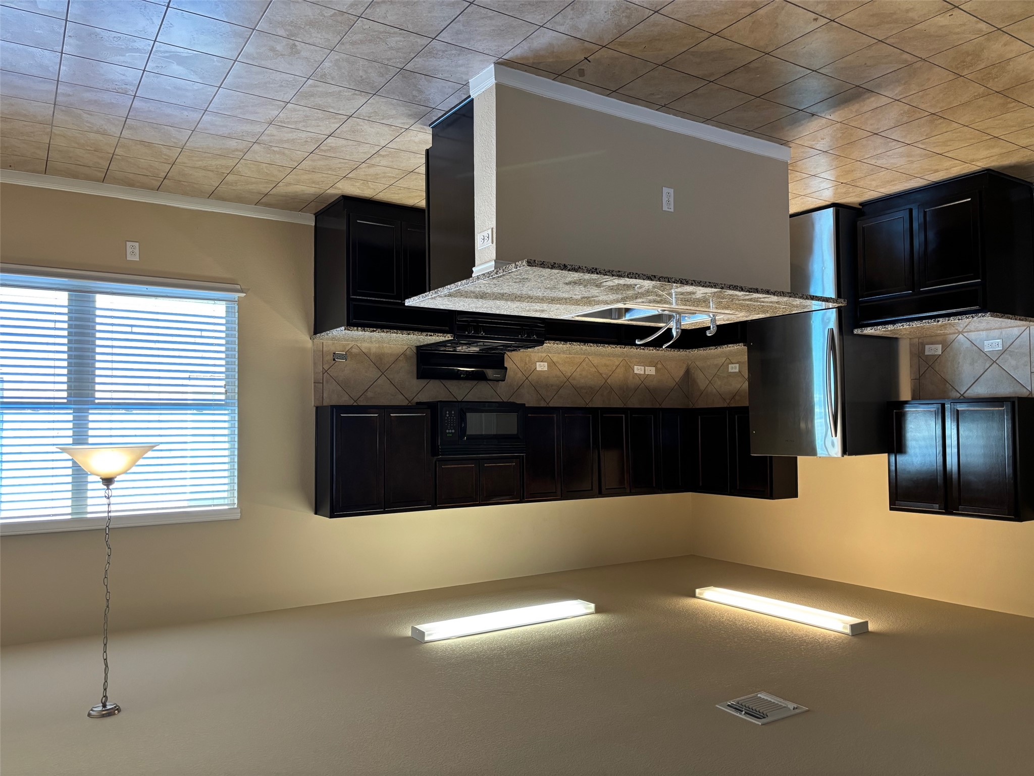 1602 Atlas Road Cedar Park, TX 78613 - Photo 4 of 13 Kitchen with tasteful backsplash, dark cabinets, black appliances, decorative light fixtures, and light tile patterned floors