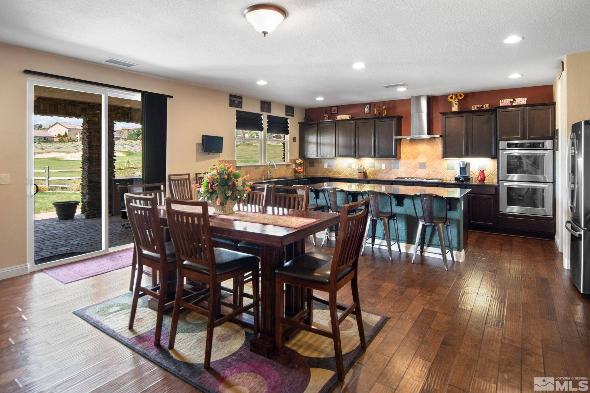 2055 Back Nine Trail Reno, NV 89523 - Photo 11 of 40 a kitchen with stainless steel appliances kitchen island granite countertop a table chairs sink and wooden floor