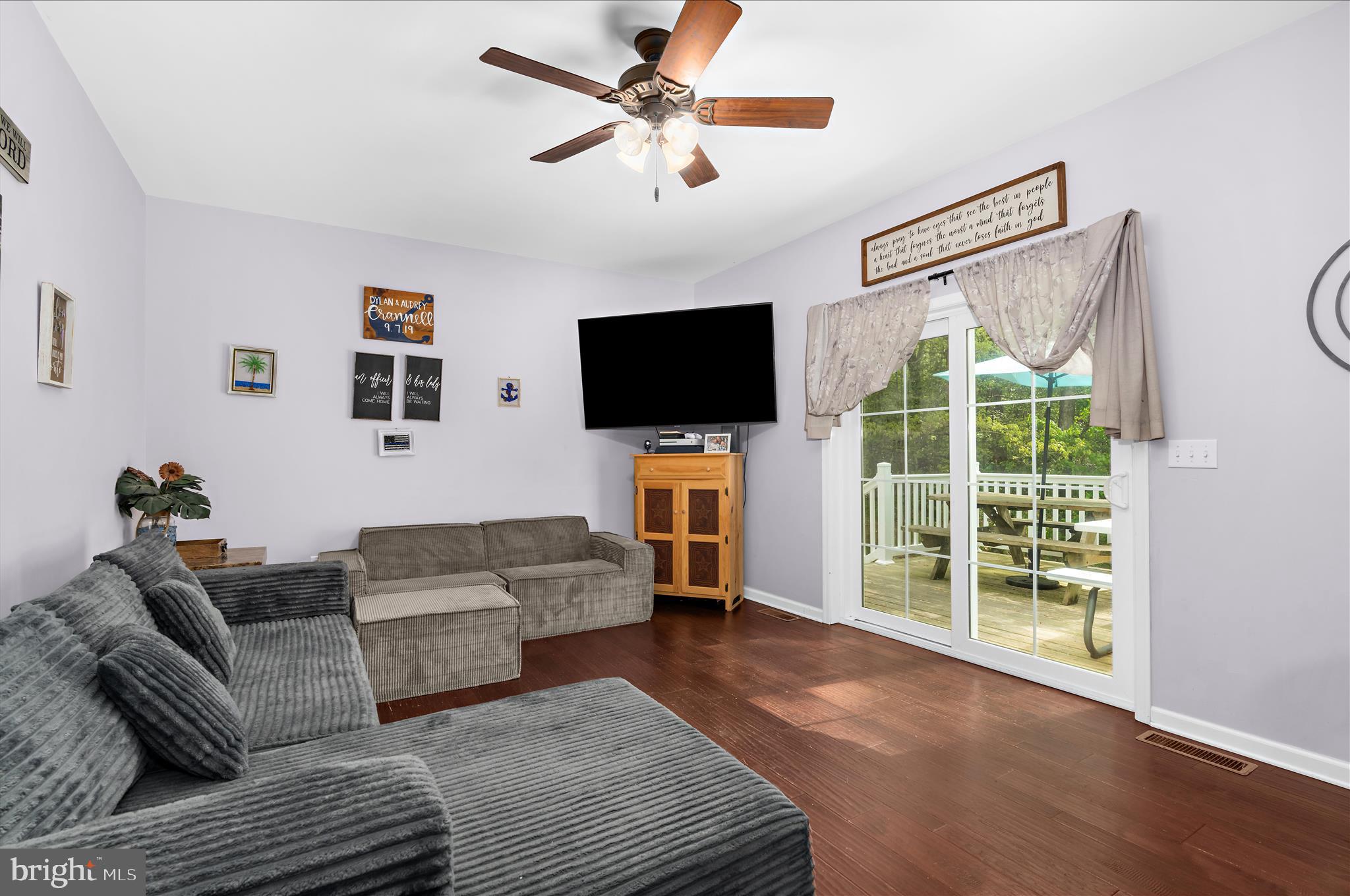 6941 Hubbard Road Hurlock, MD 21643 - Photo 9 of 71 a living room with furniture a flat screen tv and a large window