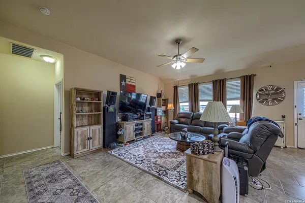 a living room with furniture a chandelier and a flat screen tv