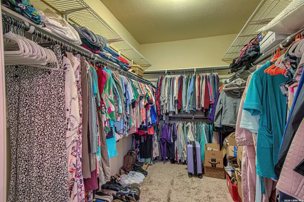a view of walk in closet with clothes