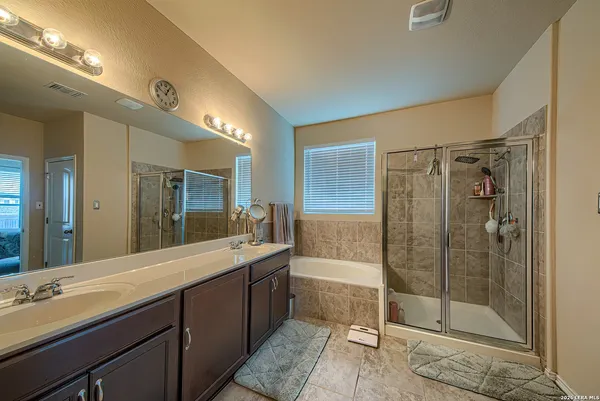 a spacious bathroom with a shower sink and mirror