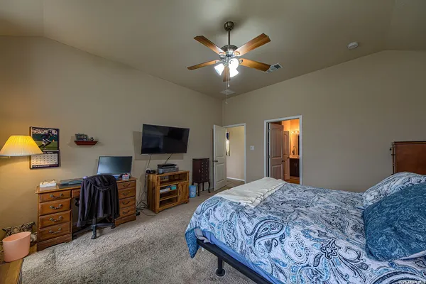 a bedroom with a bed and a flat tv screen on dresser