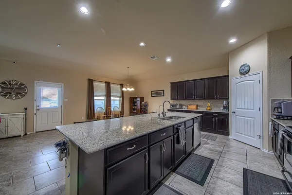 a kitchen with stainless steel appliances granite countertop a kitchen island a stove and a sink